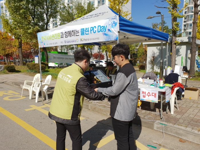 ▲1일 진행된 ‘석유관리원과 함께하는 클린 PC 데이(Day)’ 행사에서 석유관리원 직원(왼쪽)이 주민이 들고온 컴퓨터 본체 내부를 들여다 보고 있다.(한국석유관리원)