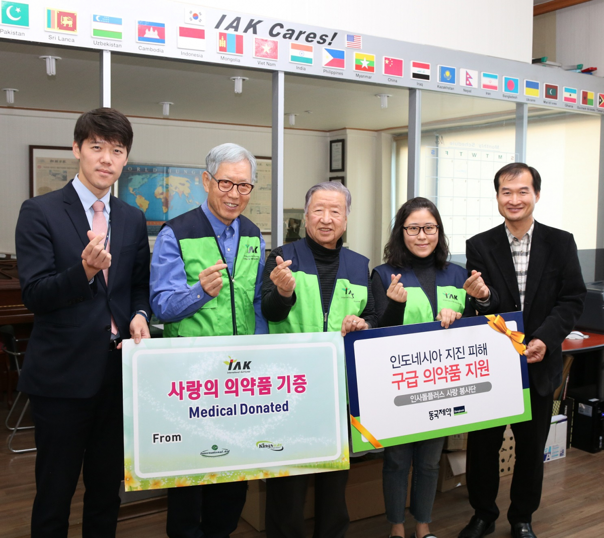 ▲동국제약 관계자가 IAK에 의약품을 전달하고 기념사진을 촬영하고 있다. (사진제공=동국제약)