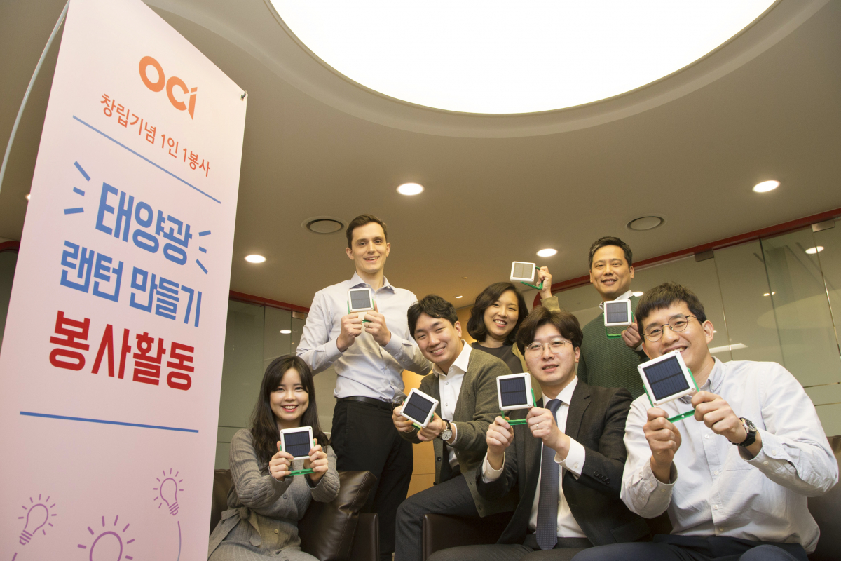 ▲OCI 직원들이 직접 조립한 태양광 손전등을 들어 보이고 있다.(사진 제공=OCI)