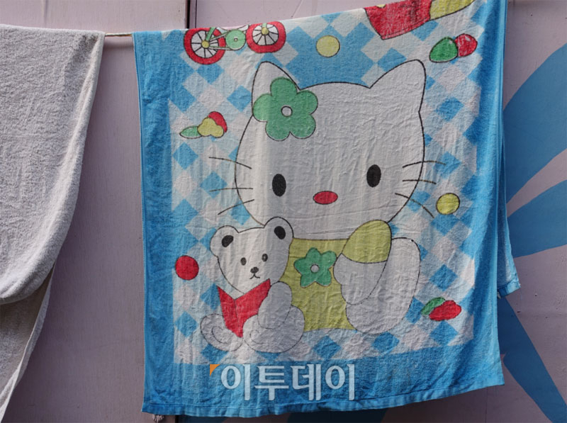 ▲빨랫줄에 걸려 있던 '헬로 키티' 수건. 뽀로로 의자도 있었다. (유정선 기자 dwt84@)