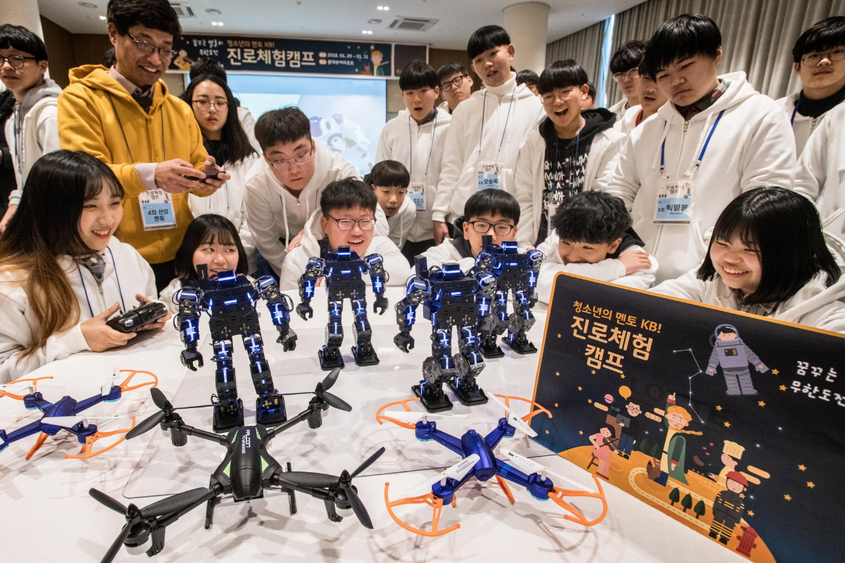 ▲KB국민은행은 1월 2박3일 일정으로 충남 부여 롯데리조트에서 중·고등학교 청소년 140여 명이 참여하는‘진로체험 캠프’를 개최했다. 참여 학생들이 4차산업 분야 전문 멘토와 함께 로봇을 체험하고 있다. 사진제공 KB국민은행 