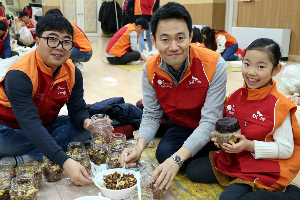 ▲SK건설은 지난 24일 서울 도봉노인종합복지관에서 과일청을 만들어 지역 사회 독거노인들에게 전달하는 가족봉사활동을 실시했다. SK건설 임직원 가족봉사단이 직접 만든 과일청을 들고 기념촬영을 하고 있다.(사진=SK건설)