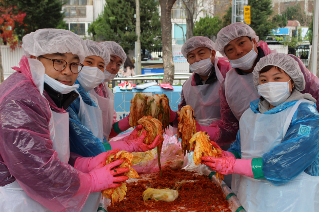 ▲라온건설 임직원들이 서울 중랑구 면목동 한신공원에서 독거 어르신들에게 전달할 김장을 담그고 있다(사진=라온건설)