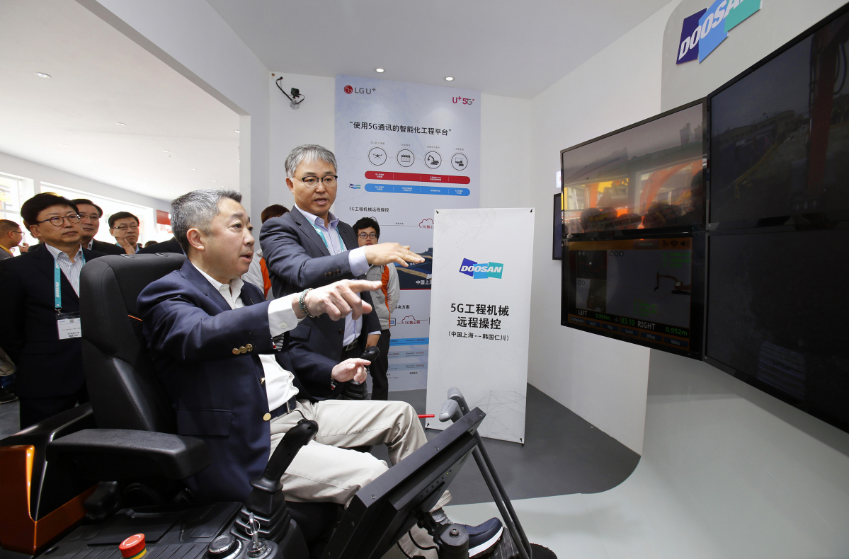 ▲박정원 두산그룹회장이 29일 중국 상하이에서 열리고 있는 국제건설기계전시회 ‘바우마 차이나’의 두산인프라코어 부스를 찾아 5G 원격제어 기술을 사용해 인천공장에 있는 굴삭기를 직접 작동해보고 있다.(사진제공=두산그룹)