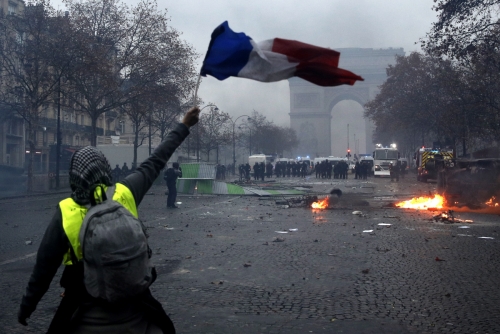 ▲1일(현지시간) 프랑스 파리 샹젤리제 거리에서 ‘노란조끼’ 시위대 중 한 명이 국기를 흔들고 있다. 파리/EPA연합뉴스
