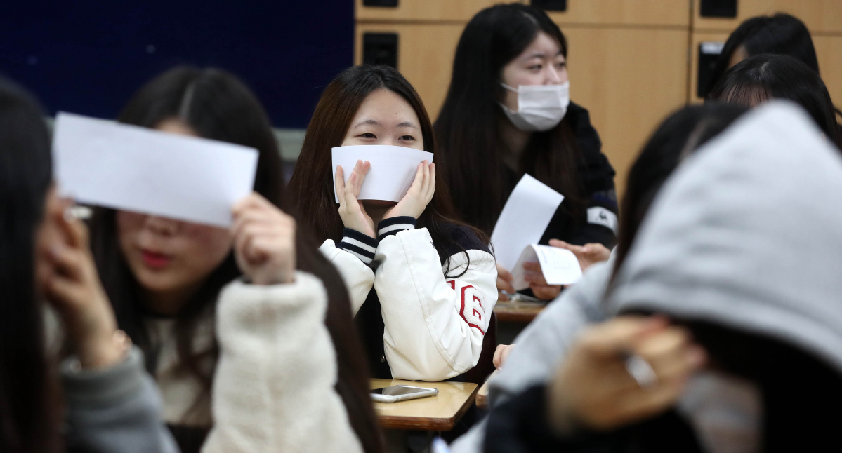 ▲수험생들이 수험표에 적어온 대학수학능력시험 가채점 결과를 표에 적어 넣은 후 생각에 잠겨 있다. (뉴시스)