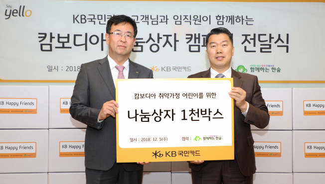 ▲5일 종로구 KB국민카드 본사에서 백문일 KB국민카드 브랜드전략부 상무(왼쪽)가 권훈상 사단법인 '함께하는 한숲' 이사장(오른쪽)에게 캄보디아 저소득가정 어린이들을 위해 KB국민카드 임직원 및 고객들이 기증한 학용품 등을 담은 '나눔상자'를 전달하고 있다.(KB국민카드)