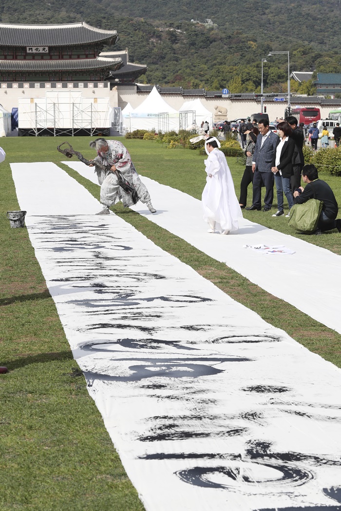 ▲제572돌 한글날을 하루 앞둔 10월 8일 오후 서울 광화문 광장에서 김동욱 서예가가 대형 광목천에 훈민정음 서문을 쓰는 서예 퍼포먼스를 하고 있다. (뉴시스)