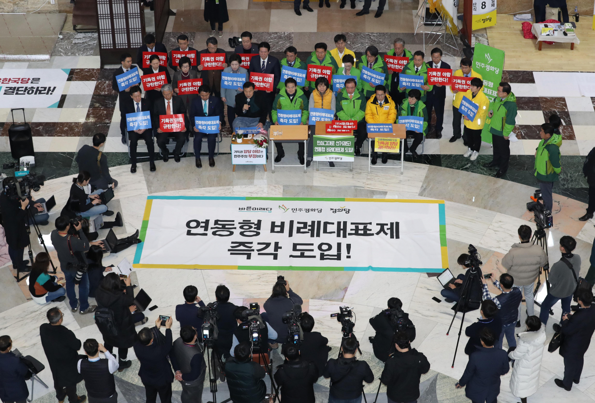 ▲바른미래당, 민주평화당, 정의당 등 야3당 대표 및 소속의원과 당직자들이 13일 국회 본청 로텐더홀에서 연동형 비례대표제를 촉구하는 시위를 하고 있다. (연합뉴스)