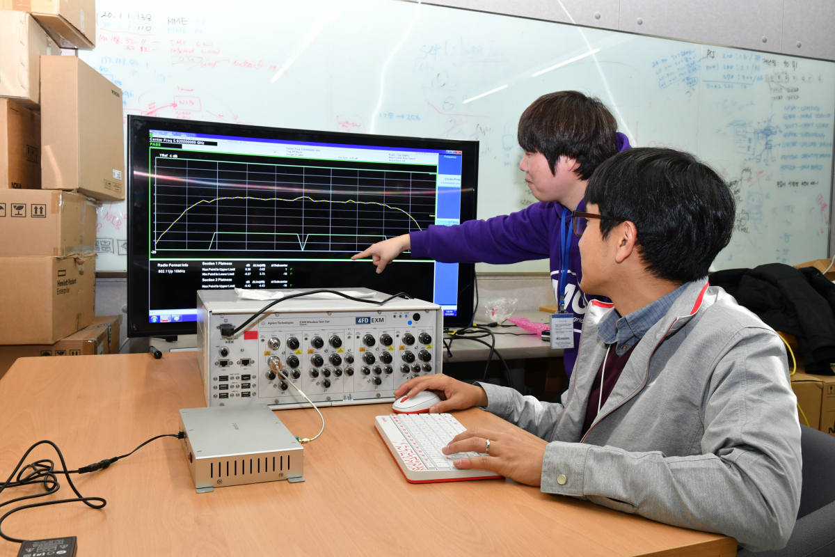 ▲KT와 아이티텔레콤이 협력해 개발한 C-V2X 단말기를 연구원들이 테스트를 진행중이다.(사진제공= KT)