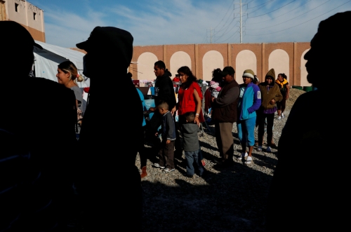 ▲12일(현지시간) 미국과 맞닿은 멕시코 티후아나 국경에서 멈춘 중미 국가 출신 이민자들이 식료품 배급을 받기 위해 줄 서 있다. 티후아나/로이터연합뉴스
