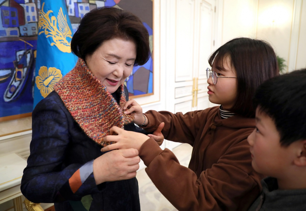 ▲지난주  청와대 본관 인왕실에서 문재인대통령 부인 김정숙 여사가 서광지역아동센터 아동을 초대해 격려하는 중 아동센터 중학생 조가영 학생에게 뜨개실로 만든 목도리를 선물로 받고 있다.(사진제공=청와대)