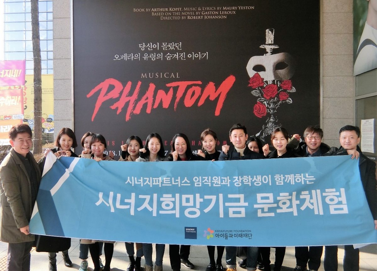 ▲시너지파트너스 및 관계사 임직원들이 지난 22일 충무아트센터에서 시너지희망기금 장학생들과 함께 뮤지컬 관람 문화체험활동을 하고 있다.(사진제공=시너지파트너스)