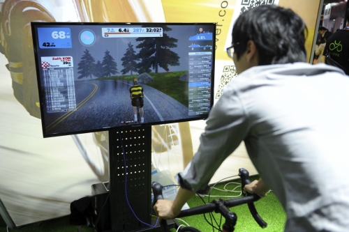 ▲중국 상하이에서 지난해 5월 6일(현지시간) 열린 자전거 박람회에서 한 참관객이 비디오 게임을 즐기고 있다. 상하이/신화뉴시스
