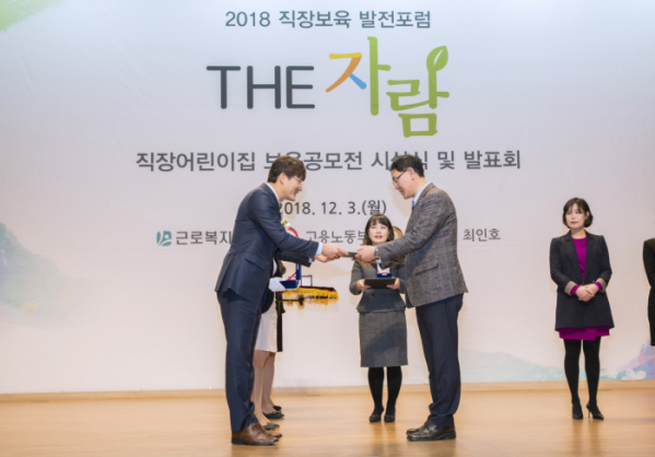 ▲지난 3일 국회의사당에서 열린 ‘2018 직장어린이집 The-자람 보육공모전’에서 최승권 GC 경영지원실장(오른쪽)이 김덕호 고용노동부 청년여성고용정책관으로부터 공간 환경디자인 부문 대상을 받고 있다.(사진제공=GC녹십자)