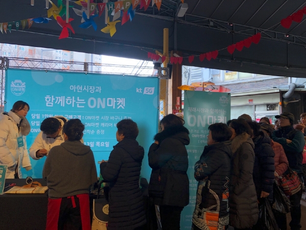 ▲KT는 지난해 12월 13일 아현 시장에 ‘온 마켓’을 설치하고 재래시장 상인들과 방문객들에게 기념품을 증정했다. (김범근 @nova)