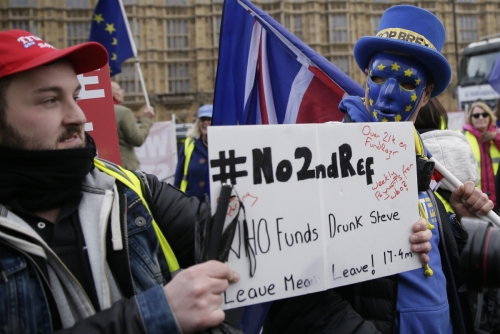 ▲지난해 12월 19일(현지시간) 영국 런던 국회의사당 앞에서 브렉시트를 지지하는 시민들이 ‘제2 국민투표’에 반대한다는 메시지를 쓴 플래카드를 들고 있다. 런던/AP연합뉴스
