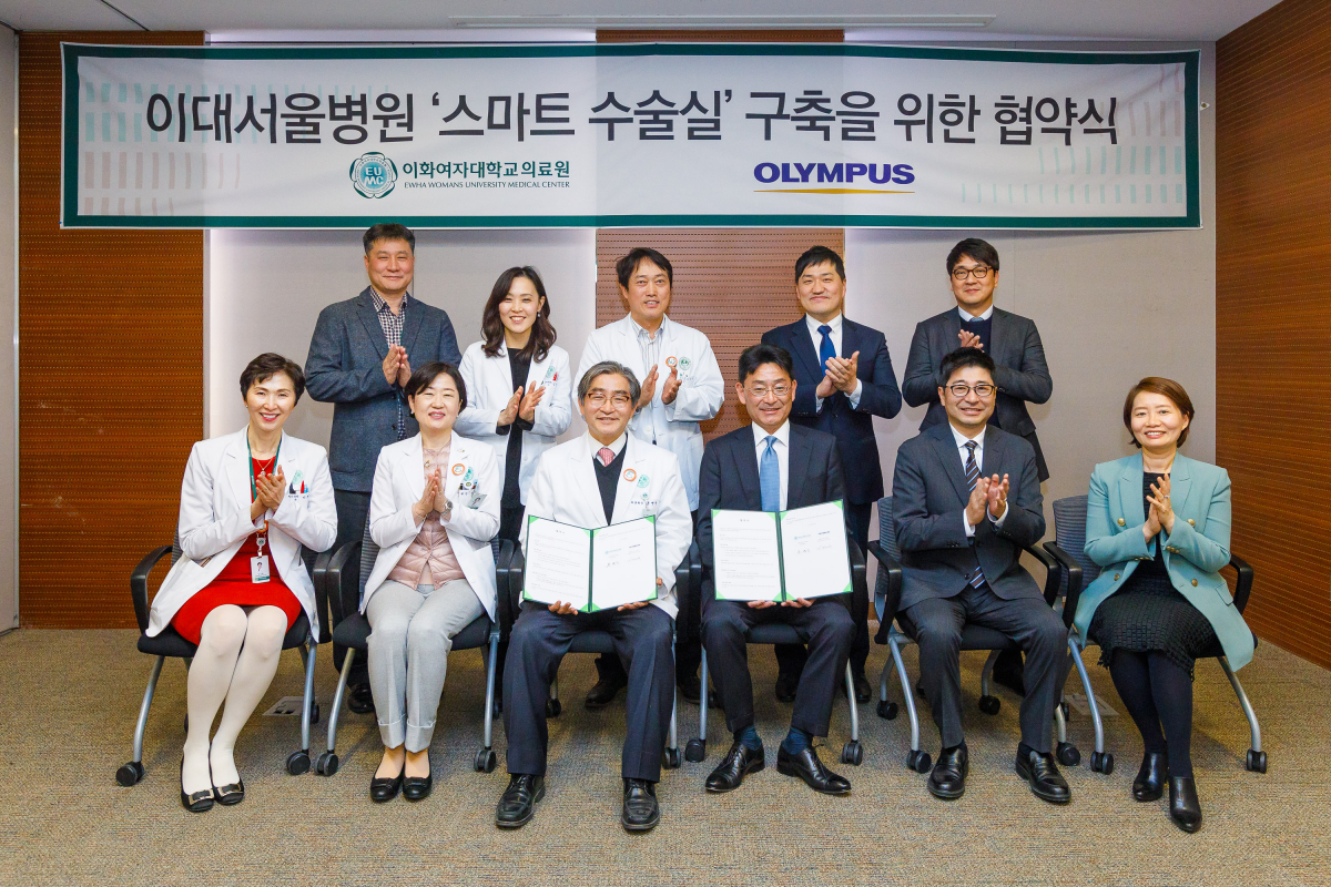 ▲이대목동병원은 8일 2층 소회의실에서 ‘스마트 수술실’ 구축을 위한 협약식을 개최했다고 밝혔다. 문병인 이화여자대학교 의료원장, 한종인 이대목동병원장, 서의교 이대서울병원 개원준비단 의료장비계획팀장 등 의료원 관계자들과 오카다 나오키 올림푸스한국 사장, 타마이 타케시 부사장, 권영민 SP 사업본부장 등 올림푸스한국 관계자가 기념 촬영을 하고 있다.(첫 번째 줄 왼쪽에서 3번째가 문병인 이화의료원장, 4번째가 오카다 나오키 올림푸스한국 사장) (이화의료원)