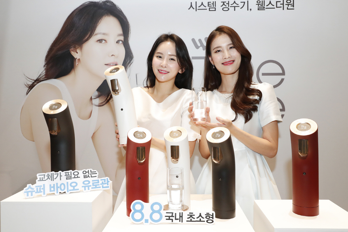 ▲교원웰스의 국내 최초 시스템 정수기 ‘웰스더원’을 홍보 모델들이 소개하고 있다(사진제공=교원웰스)