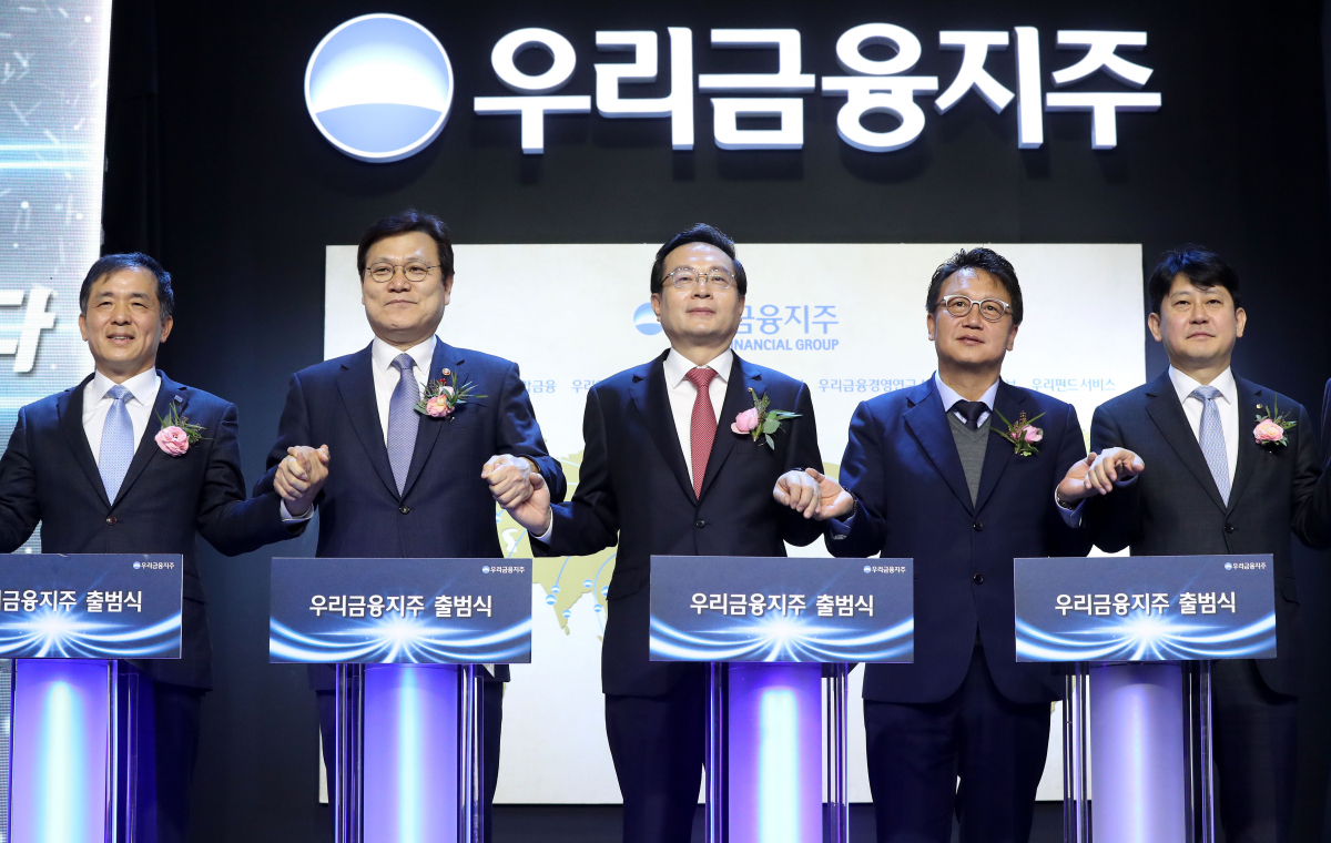 ▲손태승(왼쪽 세 번째) 우리금융지주 회장 겸 우리은행장이 14일 서울 중구 우리은행 본점에서 열린 우리금융지주 출범식에서 현판 점등식을 마친 뒤 기념촬영을 하고 있다. 왼쪽부터 위성백 예금보험공사 사장, 최종구 금융위원장, 손 회장, 민병두 국회 정무위원장, 유광열 금융감독원 수석부원장. 연합뉴스