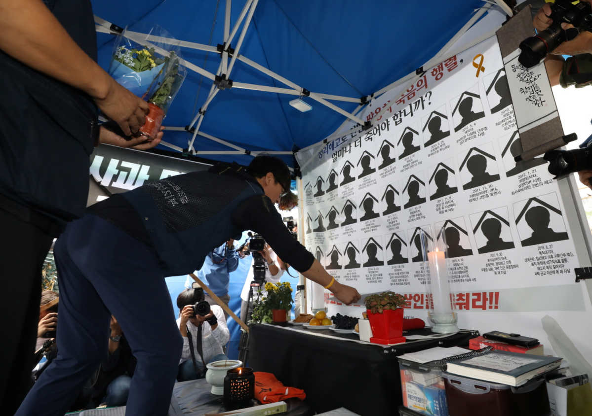 ▲쌍용자동차 노사가 해고자 119명 전원을 내년 상반기까지 복직시키기로 합의한 지난해 9월 14일 오전 서울 대한문 앞 희생자 분향소에서 김득중 금속노조 쌍용차지부장 등 지도부와 시민단체 참가자 등이 희생자 노조원을 추모하고 있다. (사진=뉴시스)