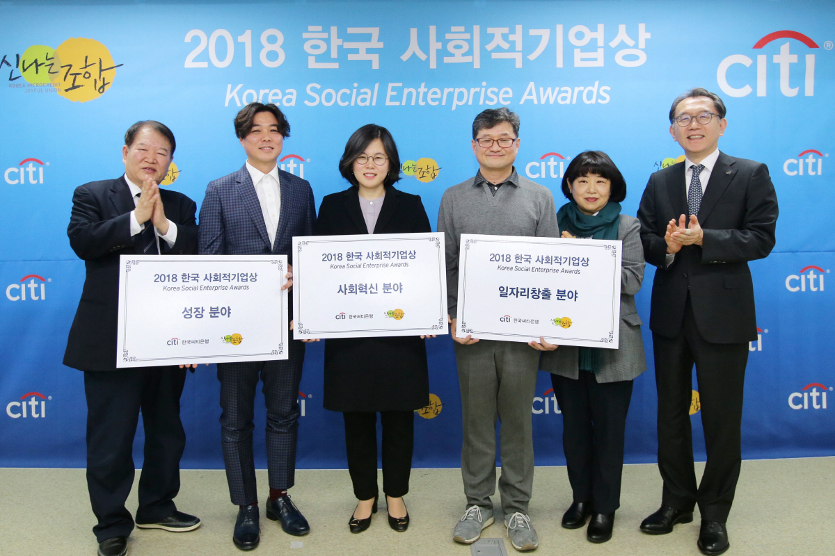 ▲한국씨티은행이 신나는조합과 함께 23일 오전 서울 성동구 소셜캠퍼스 온에서 ‘2018 한국 사회적기업상’ 시상식을 열었다. 박진회 한국씨티은행장(맨 오른쪽), 김인선 한국사회적기업진흥원장(오른쪽 두번째), 정명기 신나는조합 이사장(맨 왼쪽)이 수상기업 대표들과 함께 기념사진을 촬영하고 있다. 사진제공 한국씨티은행