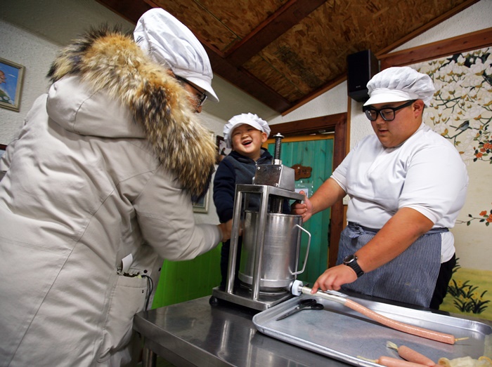 ▲압축기를 돌려 소시지를 케이싱에 넣는 소시지 만들기 체험.