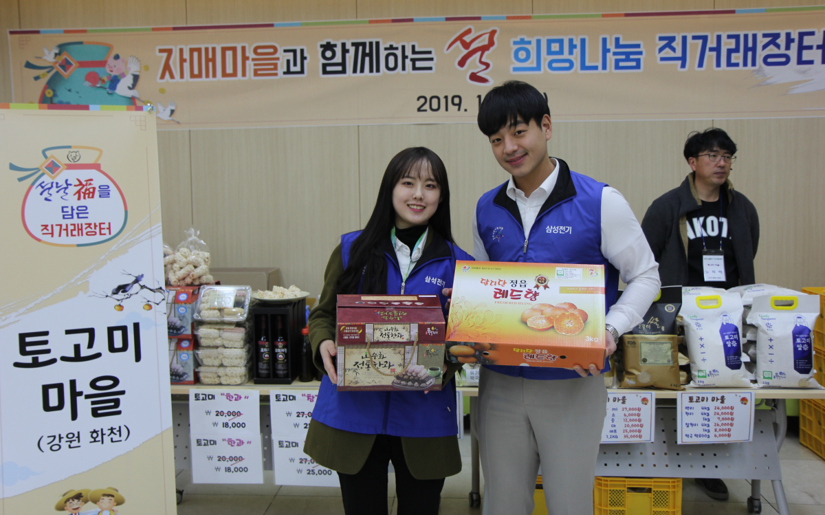 ▲삼성전기는 설을 맞아 수원, 세종, 부산 3개 사업장에서 지난 29일부터 31일까지 '설 맞이 자매마을 직거래장터’를 열었다. 삼성전기 임직원들이 농산물을 들고 있다.(사진제공 삼성전기)