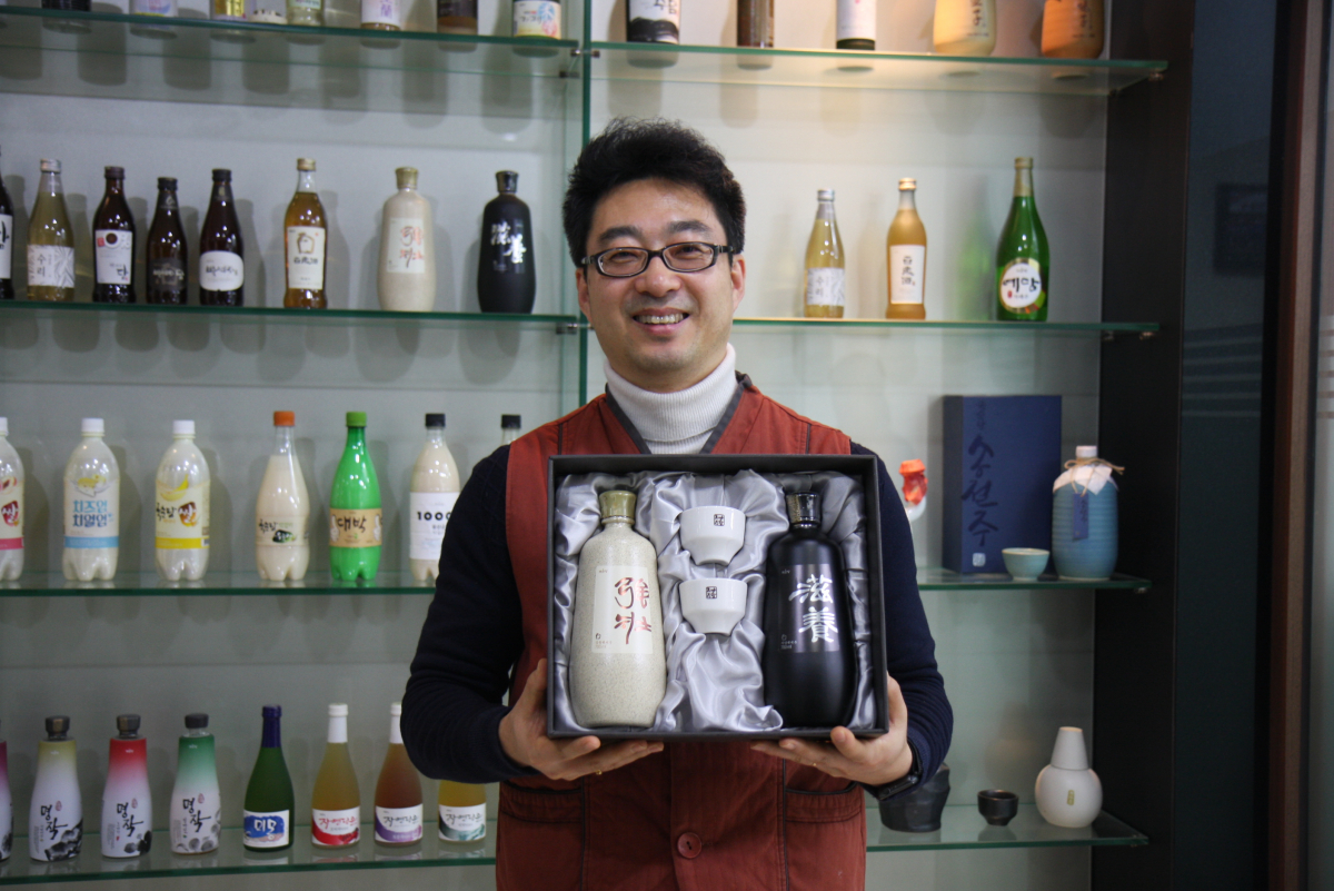 ▲신우창 국순당 연구소장이 차례주 제품을 들고 미소짓고 있다. (사진제공=국순당)