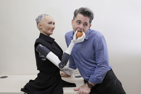 ▲핸슨로보틱스의 인공지능 로봇 소피아가 회사 설립자 데이비드 핸슨에게 사과를 먹여주고 있다. 소피아는 머신러닝 기술을 적용해 사람과 많이 얘기를 나눌수록 더 자연스러운 대화가 가능하다.  연합뉴스