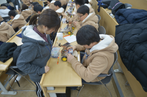 ▲코딩으로 움직이는 자동차와 로봇팔을 만드는 심화 프로젝트를 진행 중인 학생들의 모습(사진 제공=한화그룹)