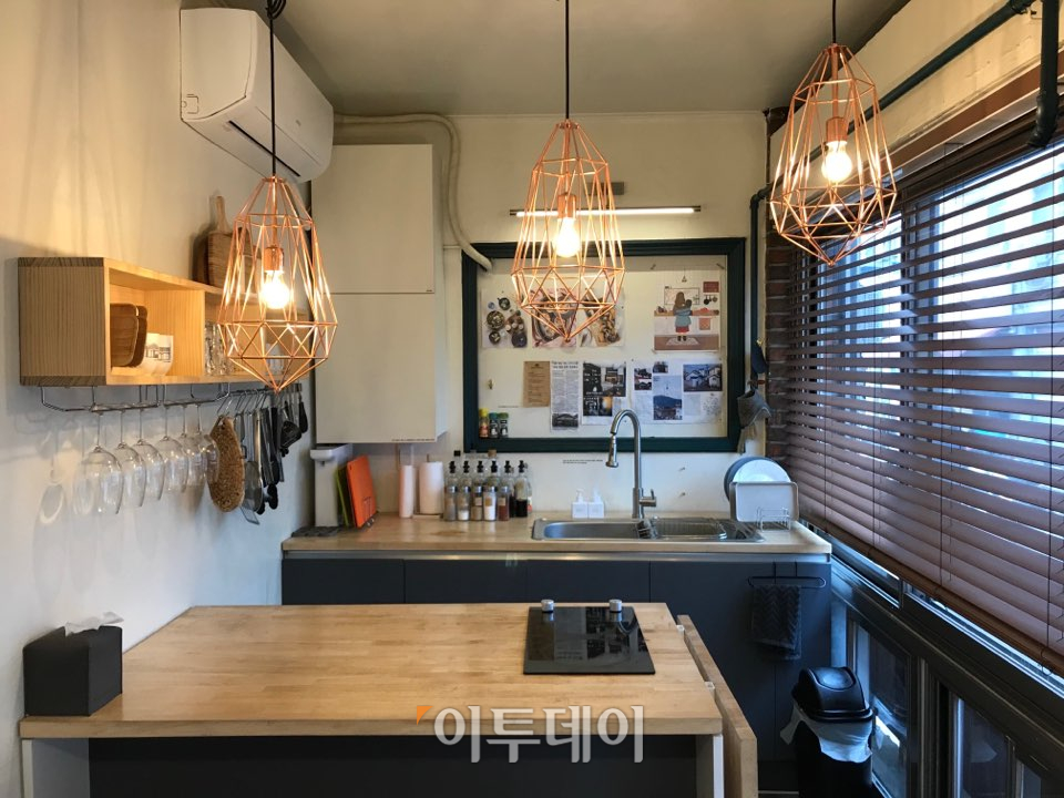 ▲‘후암주방’은 따뜻한 색의 조명을 사용해 전체적으로 안락한 느낌을 준다. ‘위쿡’처럼 전문적인 조리 기구 대신 가정용 조리 기구가 있었고, 소셜다이닝의 장소에 걸맞게 간편 요리 레시피가 곳곳에 꽂혀 있다. (나경연 기자 contest@)