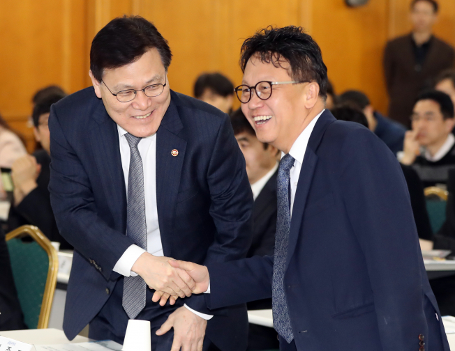 ▲민병두 국회 정무위원장과 최종구 금융위원회 위원장이 11일 서울 명동 은행회관에서 열린 'P2P 대출의 해외 제도 현황 및 국내 법제화 방안 모색 공청회'에서 악수하고 있다.(연합뉴스 )