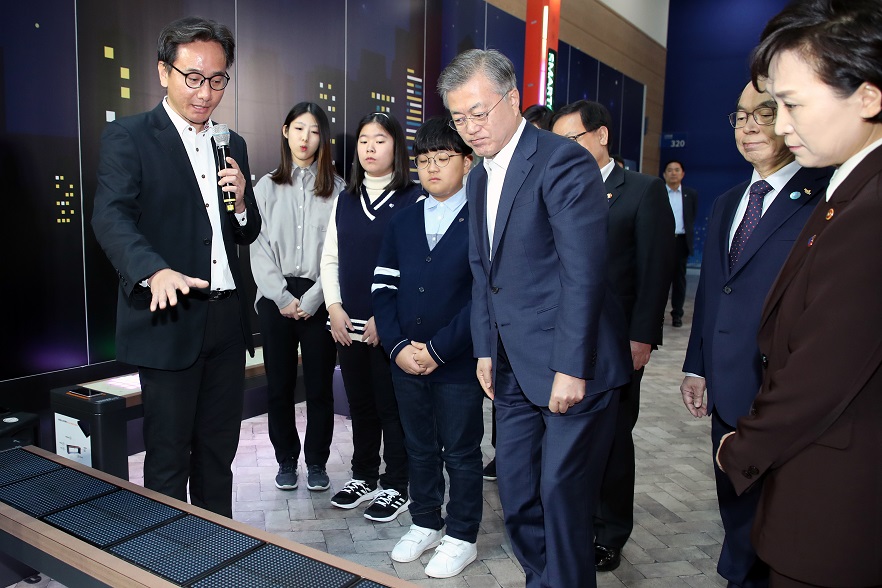 ▲문재인 대통령이 13일 오전 부산광역시 해운대구 벡스코에서 열린 스마트시티 전략발표회에 참석해 한축테크가 개발한 스마트 벤치를 체험하고 있다. 이 의자는 낮에 태양광 발전 이용해 전력을 얻은 뒤 밤에 보안 및 조명을 밝힐 수 있는 기기다. (연합뉴스)