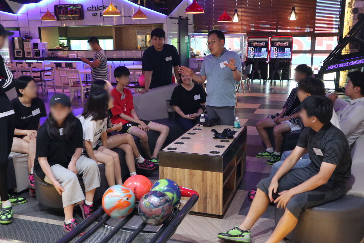 ▲유한양행 오창공장 볼링동호회의 볼링 멘토링 봉사에 나선 직원들이 늘푸른아동원의 청소년들과 볼링 수업을 진행하고 있다.