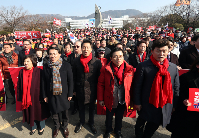 ▲자유한국당 김진태(앞줄 왼쪽 두번째부터), 오세훈, 황교안 당 대표 후보가 16일 오전 경남 창원시 의창구 경남도청 앞에서 열린 '댓글조작 김경수 규탄대회'에 참석해 애국가를 부르고 있다. (사진=연합뉴스)