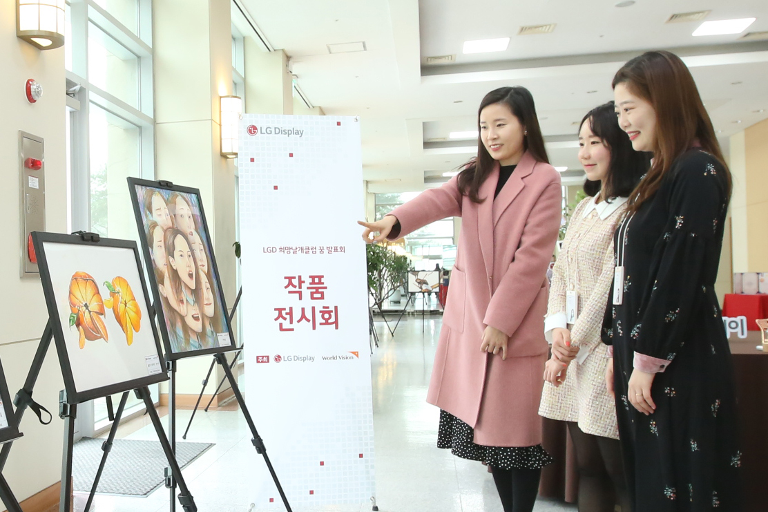 ▲15일 LG디스플레이 직원들이 희망날개클럽 후원 청소년들의 미술작품을 보고 있는 모습 (사진제공=LG디스플레이 )