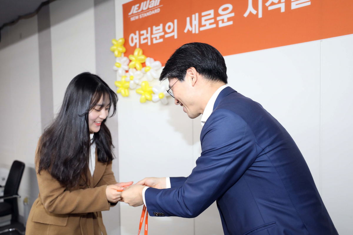 ▲18일 서울 강서구 김포공항 항공지원센터에서 열린 제주항공 신입사원 입사식에서 김재천 경영본부장이(오른쪽)이 특성화고출신 신입사원들에게 사원증을 전달하고 있다.(사진제공=제주항공)