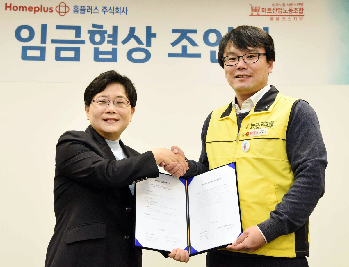 ▲임일순 홈플러스 대표이사 사장(왼쪽)과 주재현 마트산업노동조합 홈플러스지부 위원장(오른쪽)이 지난 18일 서울 강서구 홈플러스 본사에서 2019년 임금협약 조인식을 마친 후 협약서를 함께 들어 보이며 악수를 나누고 있다. (홈플러스)