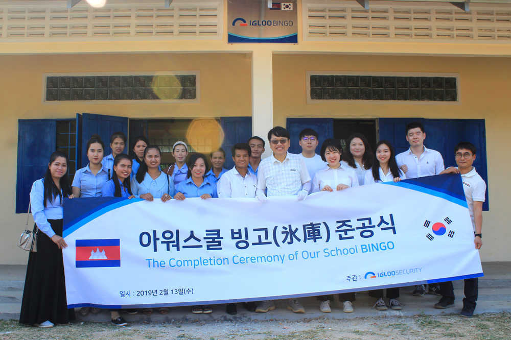 ▲이득춘 이글루시큐리티 대표(오른쪽 7번째)와 이글루시큐리티 임직원, 아워스쿨 선생님들이 캄보디아 아워스쿨 ‘빙고관’ 준공식에 참여해 기념촬영을 하고 있다.(사진 = 이글루시큐리티 제공)