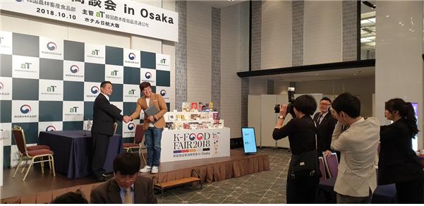 ▲2018년 10월 10일 오사카에서 열린 한국농수산식품유통공사 주관 K-Food Fair에서 아임디엔엘 정경조 대표(단상 우측)와 일본 YURI 이광석 대표가 아임떡볶이 일본 수출을 위한 협약을 맺었다.(사진제공=아임디엔엘)
