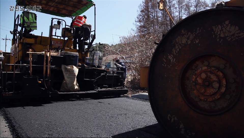 ▲강원도 인제군 도로에 SK에너지 프리미엄 아스팔트를 포장하는 모습(사진 제공=SK에너지)