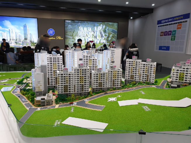 ▲‘홍제역 해링턴 플레이스’ 견본주택 모형을 둘러보는 방문객들