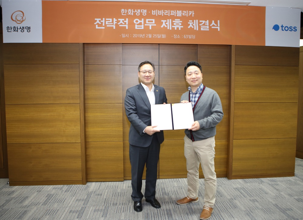 ▲한화생명 황승준 CPC전략실장(왼쪽)과 비바리퍼블리카 박재민 사업총괄이사(오른쪽)가 25일 서울 여의도 63빌딩에서 업무 제휴를 맺은 후 기념촬영을 하고 있다. (사진제공=한화생명)