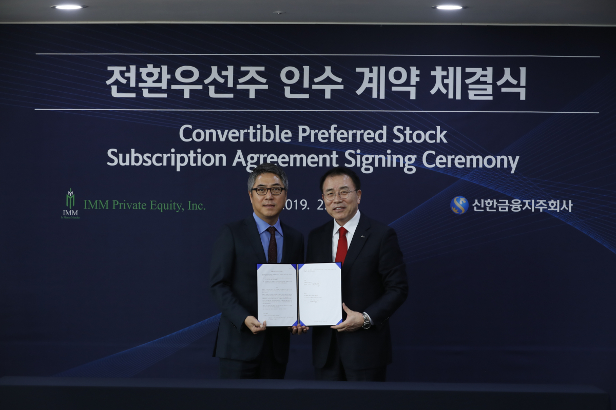 ▲조용병(오른쪽) 신한금융지주 회장과 송인준 IMM 프라이빗에쿼티 대표가 25일 신한금융지주 본사에서 열린 ‘전환우선주 인수계약 체결식’에서 기념촬영을 하고 있다.(사진제공=신한금융지주)