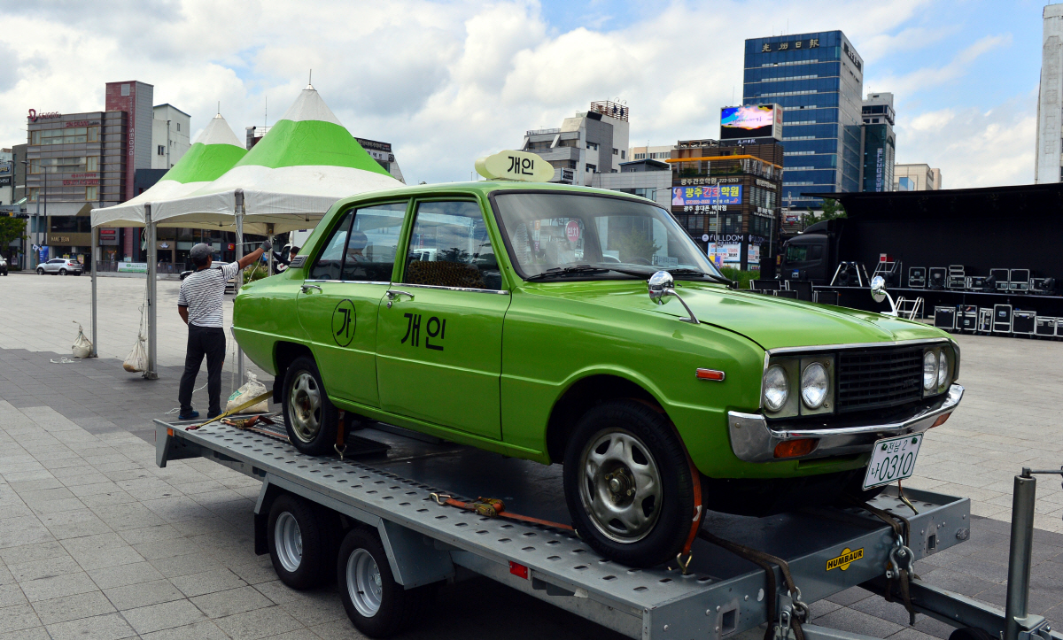 ▲영화산업의 발달로 구하기 어려운 오래된 소품은 대여보다 제작하는 시대가 됐다. 영화 ‘택시운전사’에 등장한 기아산업 브리샤는 밑그림이 된 마쓰다 파밀리아를 수입해 개조했다. 핸들 위치를 오른쪽에서 왼쪽으로 바꿨고, 엔진과 변속기도 다시 얹었다. 옛 전남도청 앞에 전시된 택시운전사의 브리샤. 뉴시스