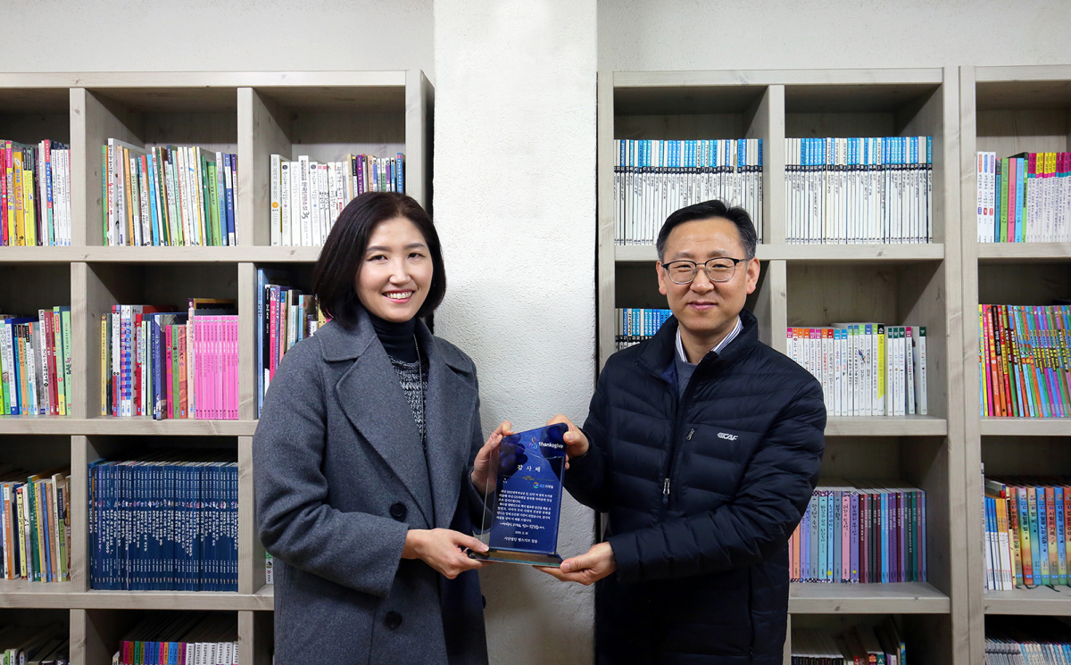 ▲작년에 352권의 책을 기부한 GS리테일 최초의 도서기부 고객참여자 김인정 고객(좌측)이 은평구 들꽃도서관에서 감사패를 전달받고 있다.(GS리테일)