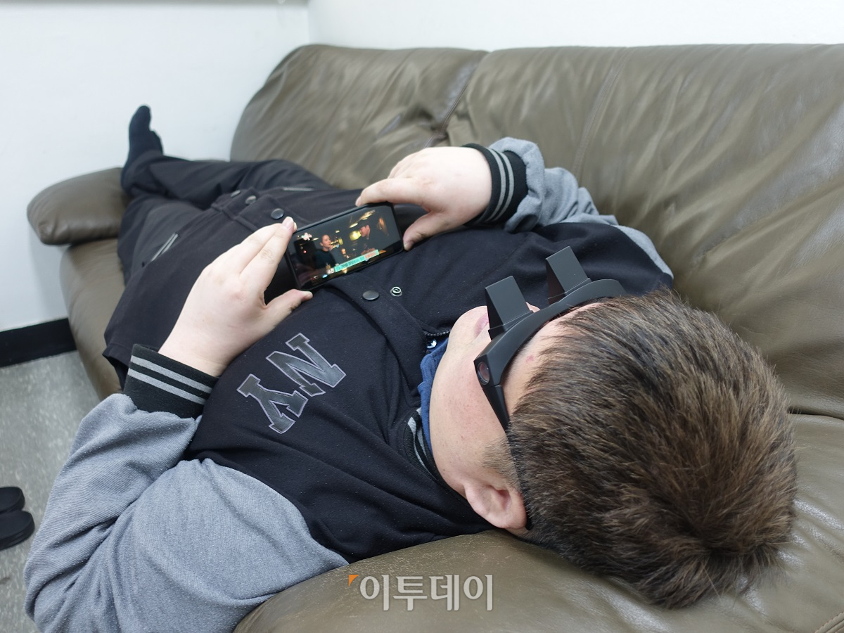 ▲'누워서 보는 안경'의 최대 장점은 소파에 누워서 고개를 들지 않아도 TV·스마트폰·노트북 등 다양한 제품을 이용할 수 있다는 점이다. (이재영 기자 ljy0403@)