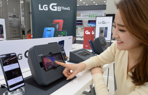 ▲7일 모델이 LG 베스트샵 서울양평점에서 붐박스부스터에 거치된  LG G8 씽큐를 체험해보고 있다. (사진제공=LG전자)