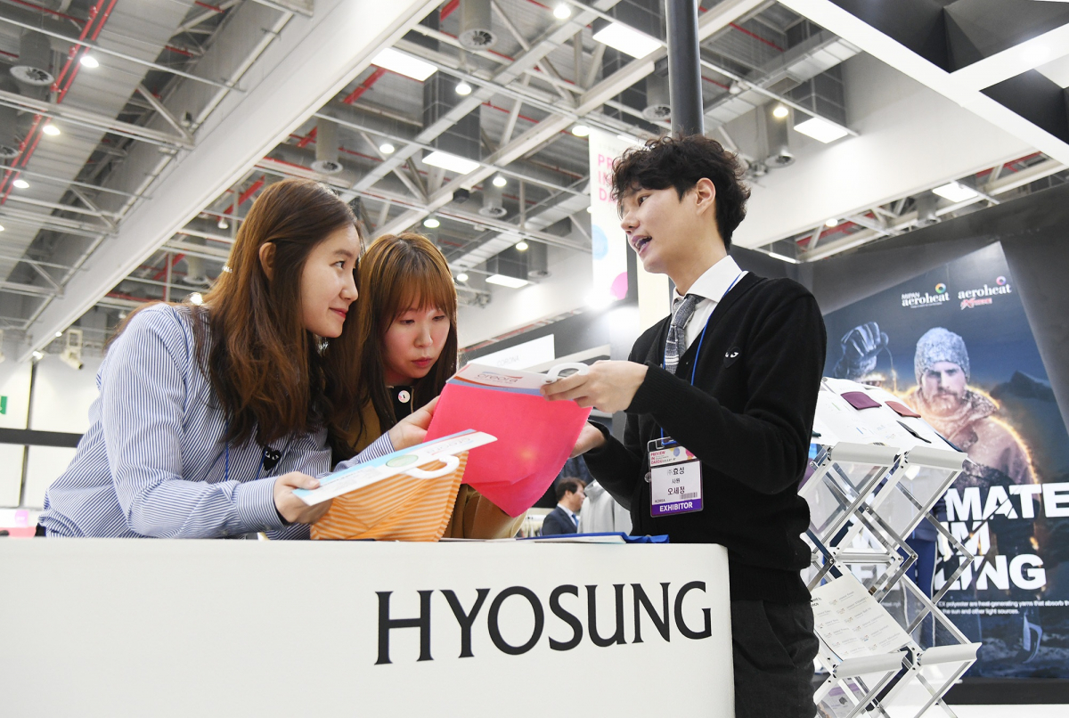 ▲대구섬유박람회에 마련된 효성 전시관에서 고객에게 효성티앤씨 원사로 만든 원단을 소개하고 있다.(사진 제공=효성)